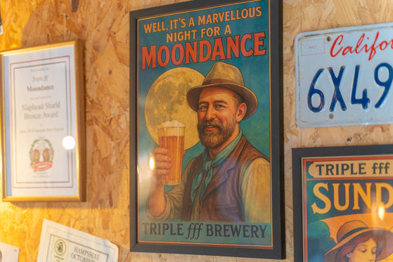 Vintage-style poster of a man with a beer and text 'Well it's a marvellous night for a Moondance' on a wooden wall with other signs.